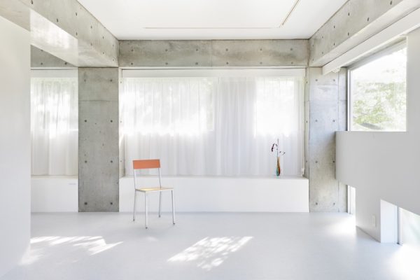 白い床と無機質なコンクリート壁のシンプルな空間