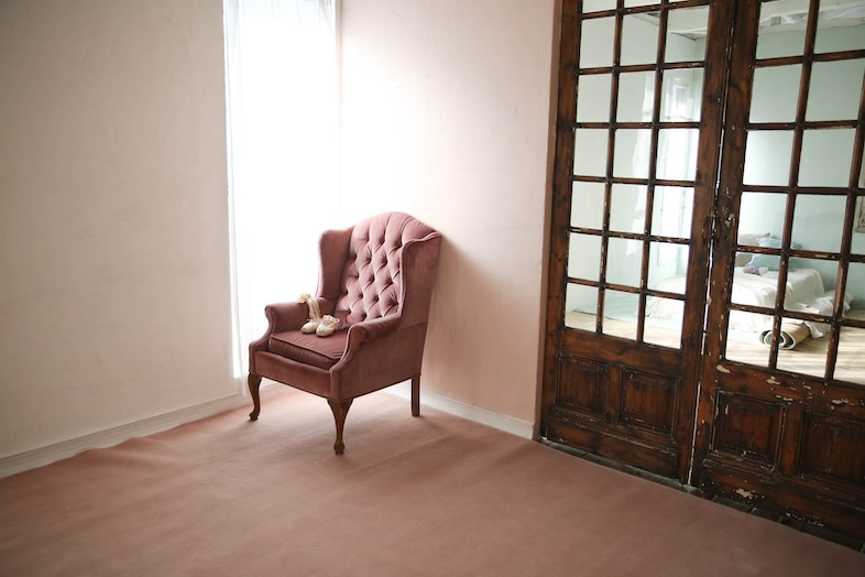 ウッド調のアンティーク扉とピンクのソファ