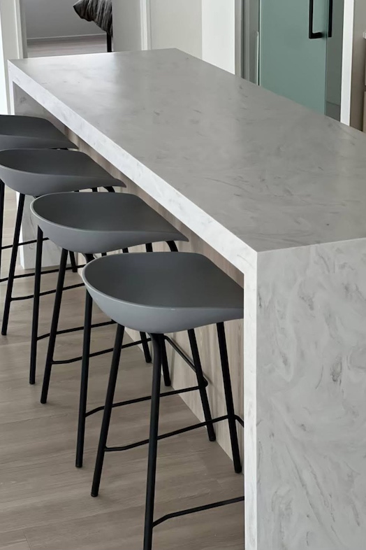 EBISU HOUSE｜大理石調のカウンターとハイチェアが配置されたモダンなキッチン空間