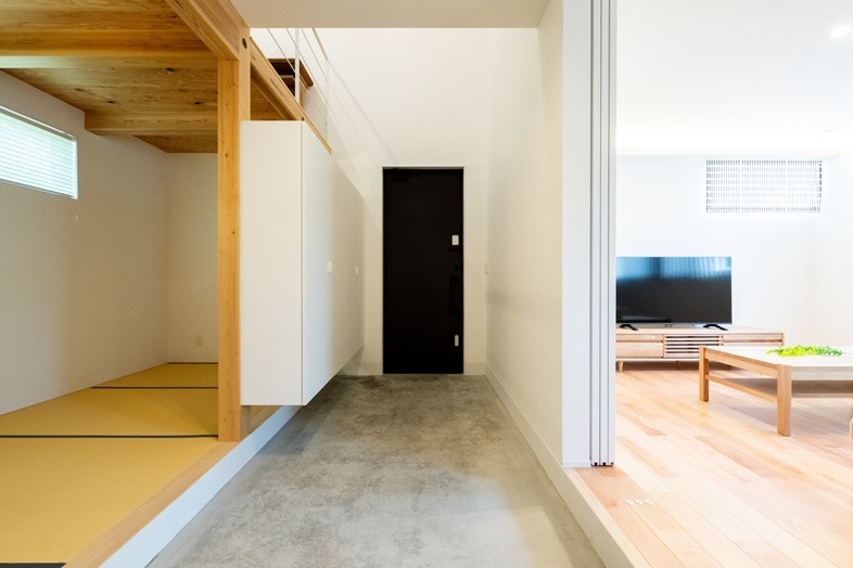 玄関から続くコンクリート床の左右にお部屋が展開する開放的な間取り