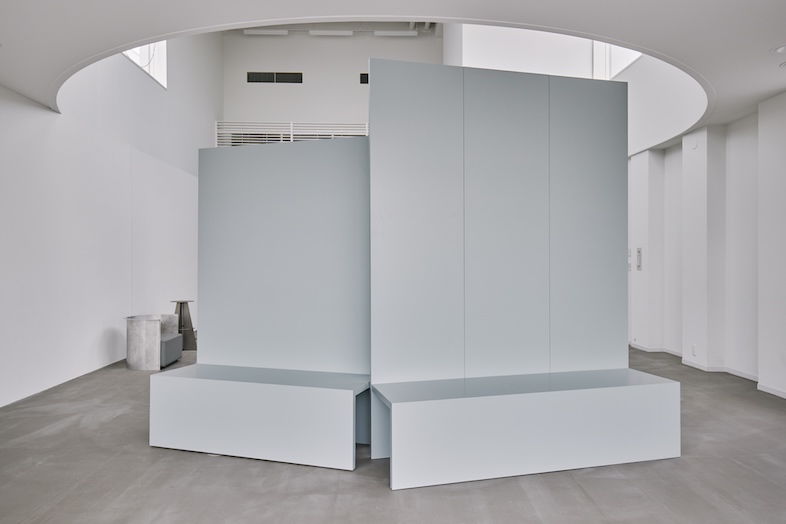 FORMEI｜薄いブルーグレーの稼働壁は、表面の段差を展示会等の棚としてや椅子としても使用可能