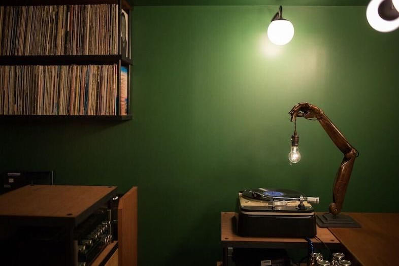 BAR TAMBI｜グリーンの壁の前に置かれたターンテーブルとレコード棚