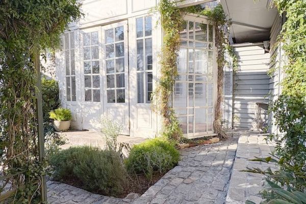 柔らかな自然光が差し込む、大きな白い扉が印象的なテラス