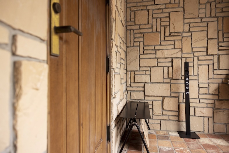 Studio Mekuru｜【1F Prologue】ウッドドアと石壁が温かみを演出する、シンプルながら印象に残るエントランス空間