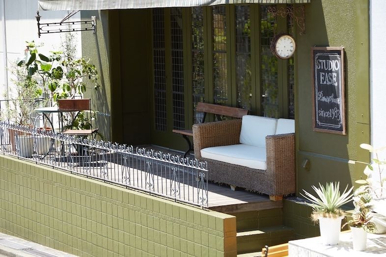 EASE 目黒 -GROUND LIBRARY-｜グリーンの壁とシックな白ソファが印象的なテラス空間は、フォトジェニックな1枚や屋外シーンに最適