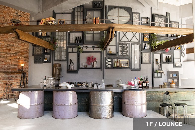 EASE -世田谷砧-｜【1F LOUNGE】ドラム缶の椅子と壁面のデザインが目をひくバーカウンター