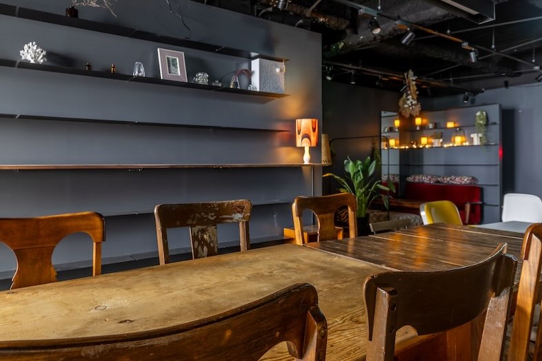 CafefleurLOUNGE心斎橋｜落ち着いたグレートーンの棚とウッドテーブルのある洗練されたカフェ空間