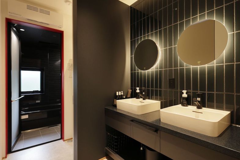 Villa Hokuto｜【洗面所】丸いミラーと黒タイルのホテルライクな洗面