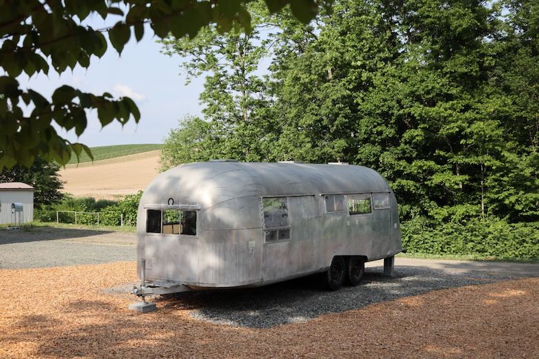 Villa Hokuto｜【エアストリーム外観】畑に佇むシルバーのエアストリームは、旅番組やリアリティ番組のイントロカットに最適