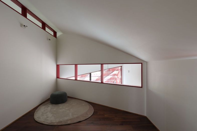 Villa Hokuto｜【サブベッドルーム】窓越しに赤フレームが映える静かな空間は、朝のルーティン撮影や雑誌カットに最適