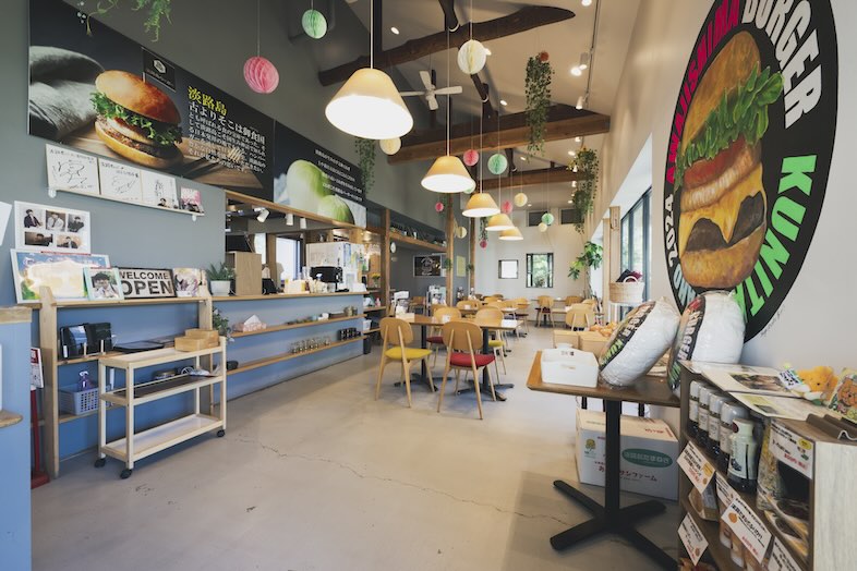 淡路島バーガー 国立谷保店｜キッチンの活気まで伝わりそうな温かみのあるカフェ空間 ※ピンクや緑の吊り下げ装飾は、現在は設置しておりません。