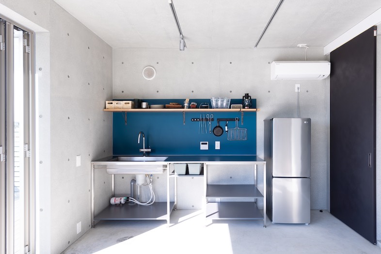 KURUWA OCEAN VIEW｜ブルーの壁紙が目を引くアウトドアキッチン