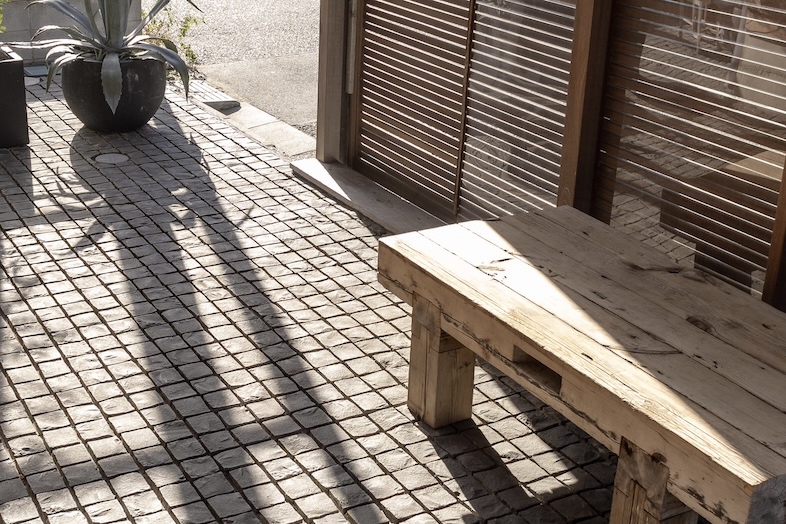 JF KUGENUMA STUDIO｜【入り口付近】石畳と木壁、ウッドチェアが絶妙にマッチしたテラス