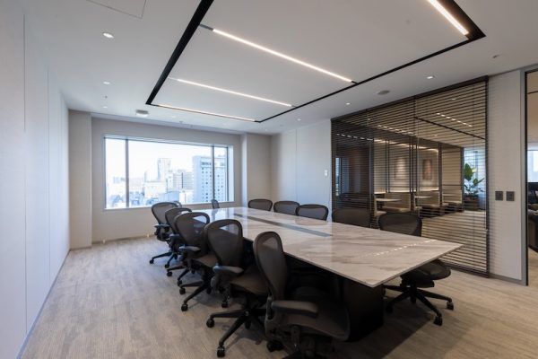 大きな窓からの自然光が緊張感の中にクリーンな企業イメージを付与