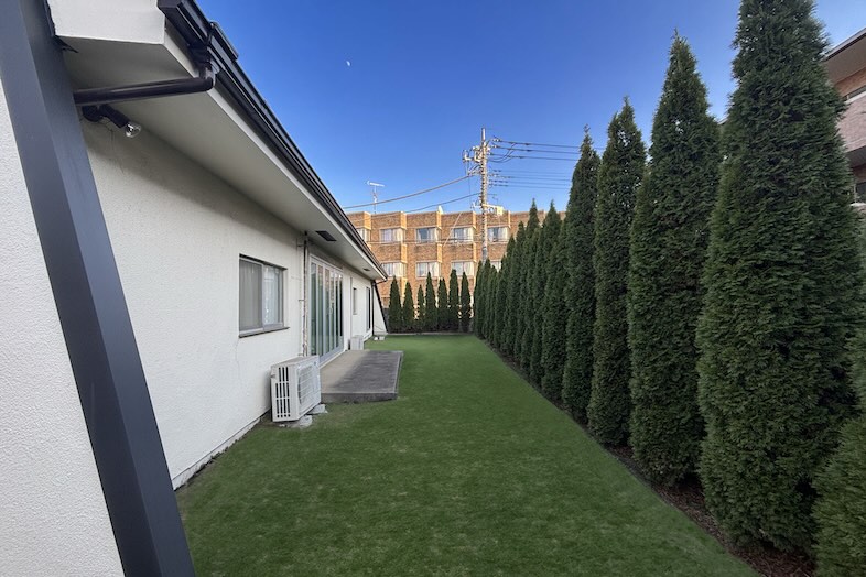 トンボハウススタジオ｜【中庭】白い外壁と芝生、植樹の調和は米軍ハウスならでは