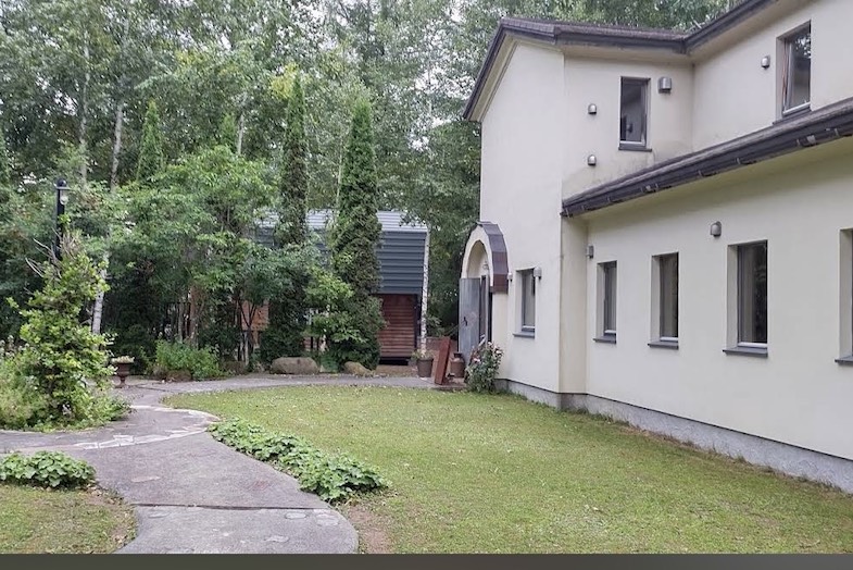 美瑛町十勝岳が一望できる森のレストラン｜白壁と芝生のコントラストを活かし、映像作品のロケ地として