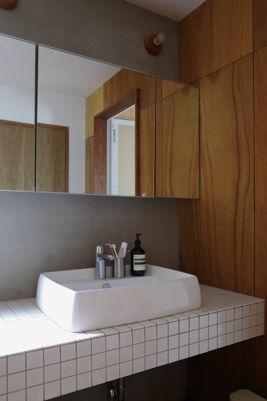 鎌倉スタジオオレンジ｜【1F 洗面所】木壁とミラーの組み合わせが、暮らしに寄り添うリアルな生活感を表現