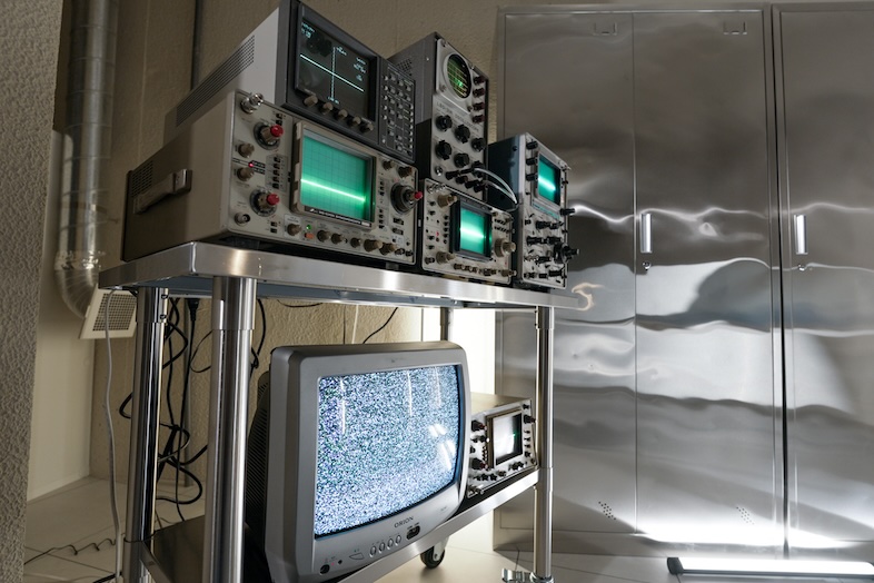 STUDIO PODBASE グリッドスペース旗の台｜モニターのノイズ画面がレトロな映像演出を感じさせる複数の計測機器やブラウン管テレビがラックに並んだカット