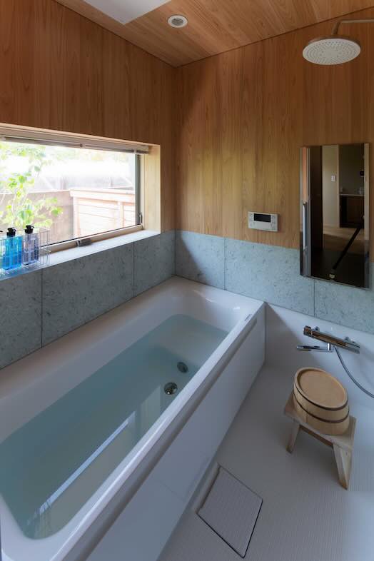 季の棲家｜窓から庭の植栽が見え、自然光も柔らかく入る落ち着いたバスルーム