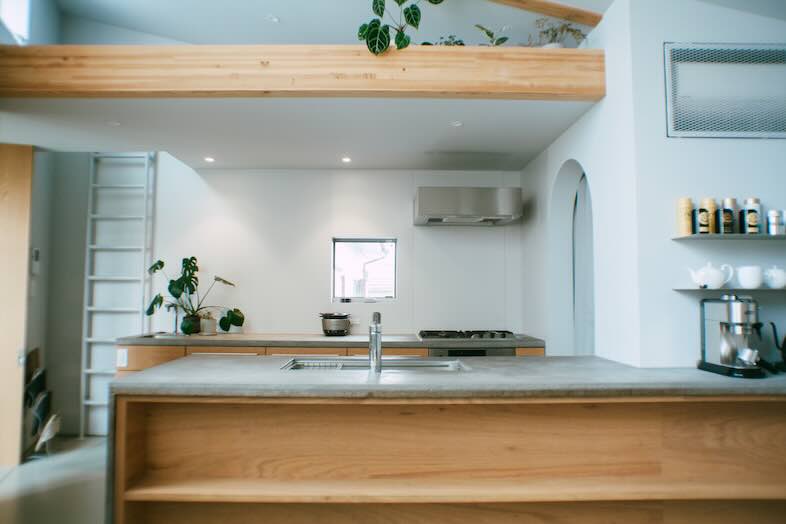 STUDIO MAME｜木製カウンターと白い壁が調和する広いキッチンスペース