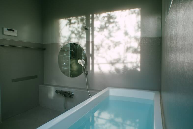 STUDIO MAME｜大きな窓から差し込む柔らかな自然光が壁に揺れるバスルーム