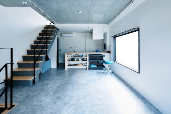 コンクリート調の床と白い壁が広がる開放的な空間キッチンスペース