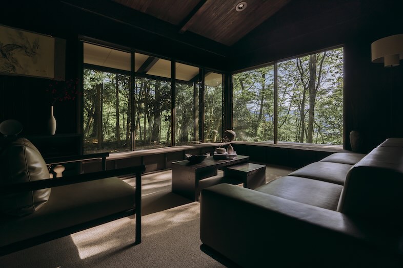 ENN HAKONE｜低いソファとローテーブルが配された和モダンな空間は、吹き抜けの開放感と森の借景を活かした撮影が可