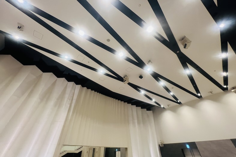 東松山 元結婚式場 LEAF｜【1F 大ホール】大ホールの特徴的な幾何学的な天井デザインを見上げたカット