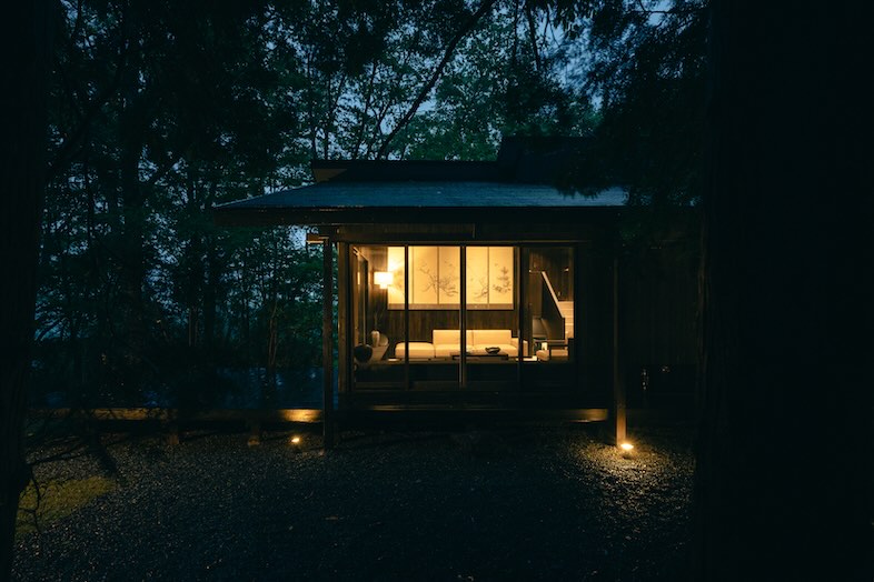 ENN HAKONE｜室内の灯りが森の中に温かく漏れる外観の夜景カット