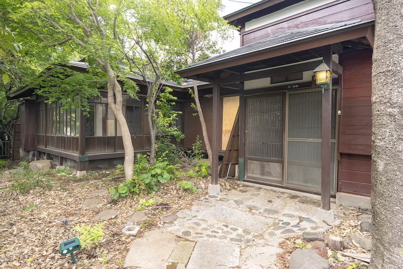 S-Studio保土ヶ谷｜苔むした石畳と緑の木々が広がる屋外庭の引き画