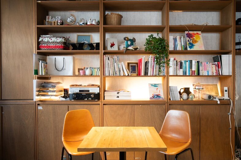 GOBLIN.参宮橋CAFE店｜小ぶりな木製テーブルを囲む書棚前は二人だけの対談撮影に最適