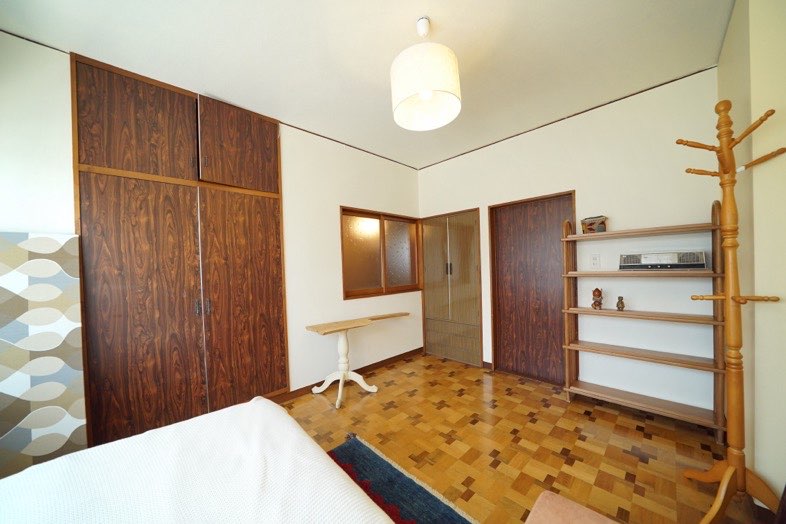 ノーマンハウス馬込｜【母屋2F】レトロな木目の床、クローゼット、棚、洋服かけのある洋室