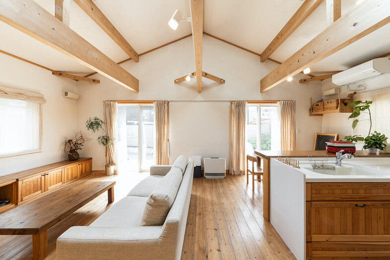 guesthouse MOSHIMO｜【LDK】抜け感のある高い天井と梁、無垢材の床や家具が温かみを添えるLDK