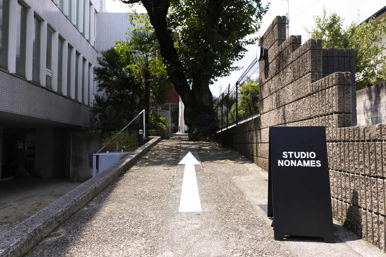 STUDIO NONAMES｜緑道の先に立つ看板が、スタジオ入口までわかりやすく案内します