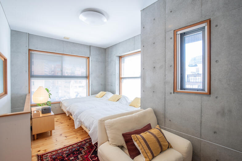 apartment2122｜コンクリート壁と三台のベッドが並ぶ寝室は宿泊シーンにも