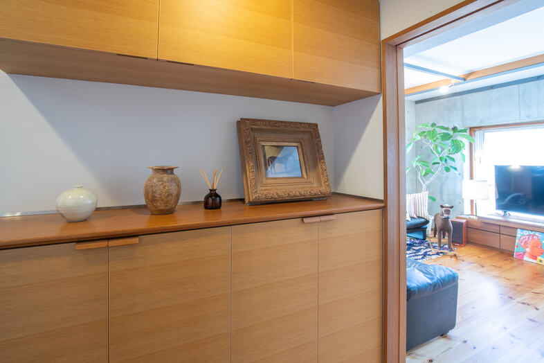 apartment2122｜木目の収納にアートや小物を配した、温もりのある空間