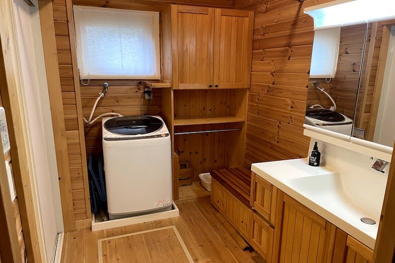 guesthouse MOSHIMO｜【洗面・浴室】木目を基調としたナチュラル空間には洗濯機と洗面台を完備