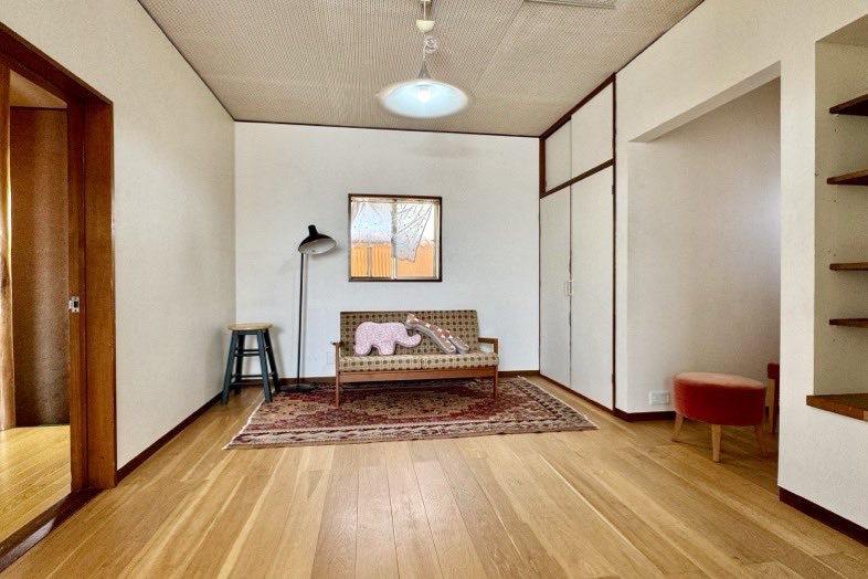 ノーマンハウス馬込｜【母屋2F】ソファ、ライト、窓、椅子、ぬいぐるみのあるシンプルな洋室