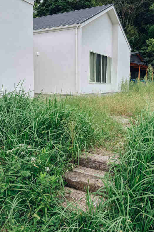 STUDIO FINN｜草花に囲まれた小道と白い外壁を切り取った屋外シーンの撮影に