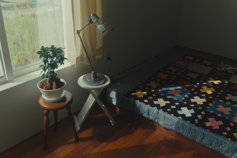 STUDIO FINN｜窓辺の緑とパッチワークの小物が醸す静かな朝の一場面