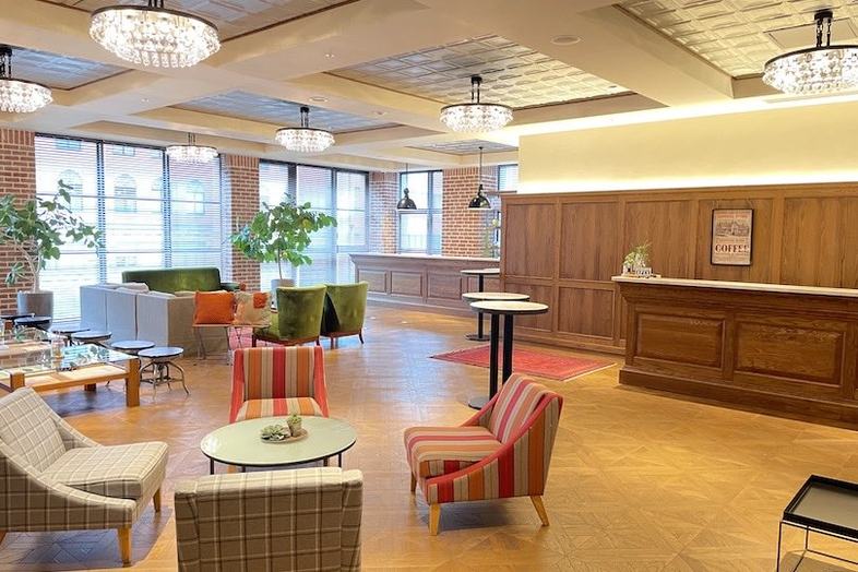 NEEDS京都烏丸(旧 InStyle wedding KYOTO)｜【4F サロン】木製家具と鮮やかなチェアを配した明るい空間でインタビューや歓談シーンが可