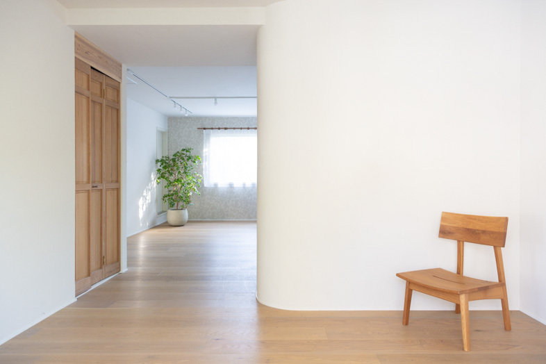 mimosa house︎ リゾート｜【2F】曲線壁と木製チェアを生かした奥行きのある構図