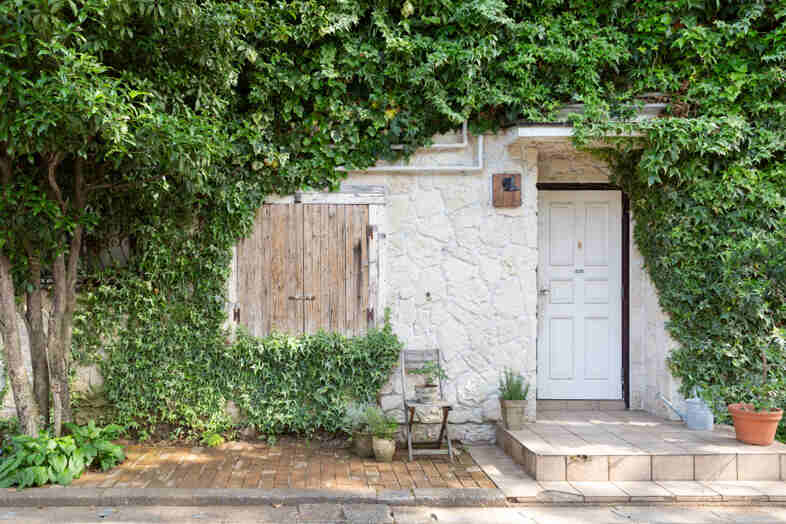 mimosa house︎ リゾート｜【外観】石壁と豊かなグリーンに囲まれた玄関