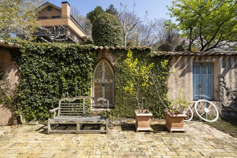 Greige House Studio by KIC｜【パティオ】木製ベンチと鉢植えのグリーンが並ぶ庭先は、日常を感じさせる空間