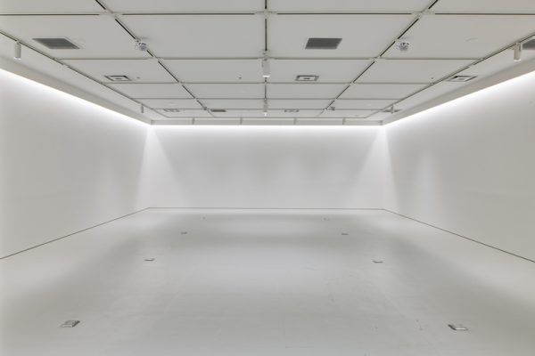 左右対称に広がる白壁と光のラインが、端正でミニマルな構図を生み出す