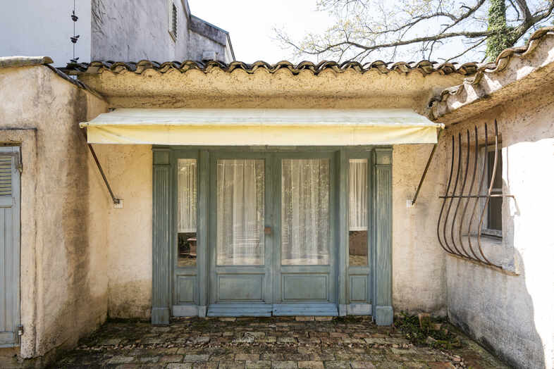 Greige House Studio by KIC｜【パティオ】レースカーテン越しの柔らかな光が差し込む、素朴で温かみのある入口