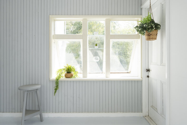 Greige House Studio by KIC｜【センターリビング】グレーの壁と窓辺の植物がマッチし、静かで落ち着いた一角