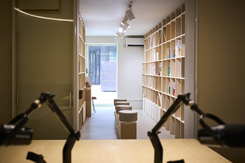 Video & Podcast Studio | STORYS STAND IKEJIRI｜マイク越しに本棚が垣間見える構図は、奥行きを活かした画が撮れる