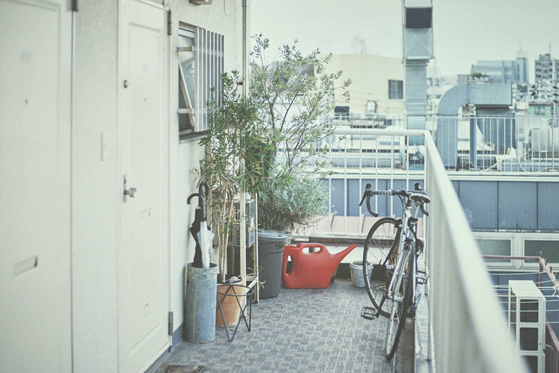 SEE YOU TOMORROW｜鉢植えと自転車が置かれた生活感のある廊下