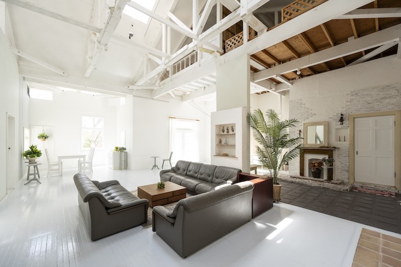 Greige House Studio by KIC｜【センターリビング】天井高を活かした大空間に、レザーソファと暖炉が映えるリビングスペース